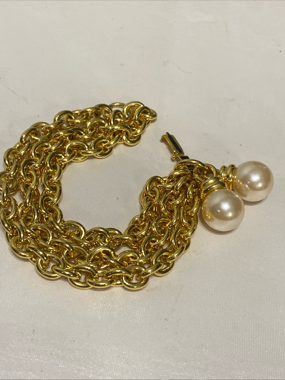 Multi-strand chunky chain bracelet highlighted by two large dangling faux pearl